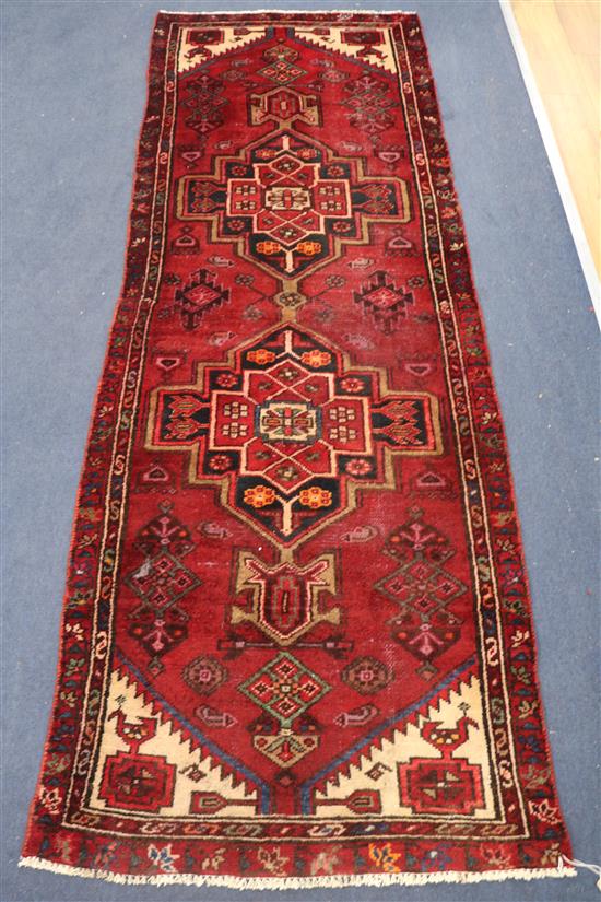 A Caucasian red ground small runner, 214 x 76cm